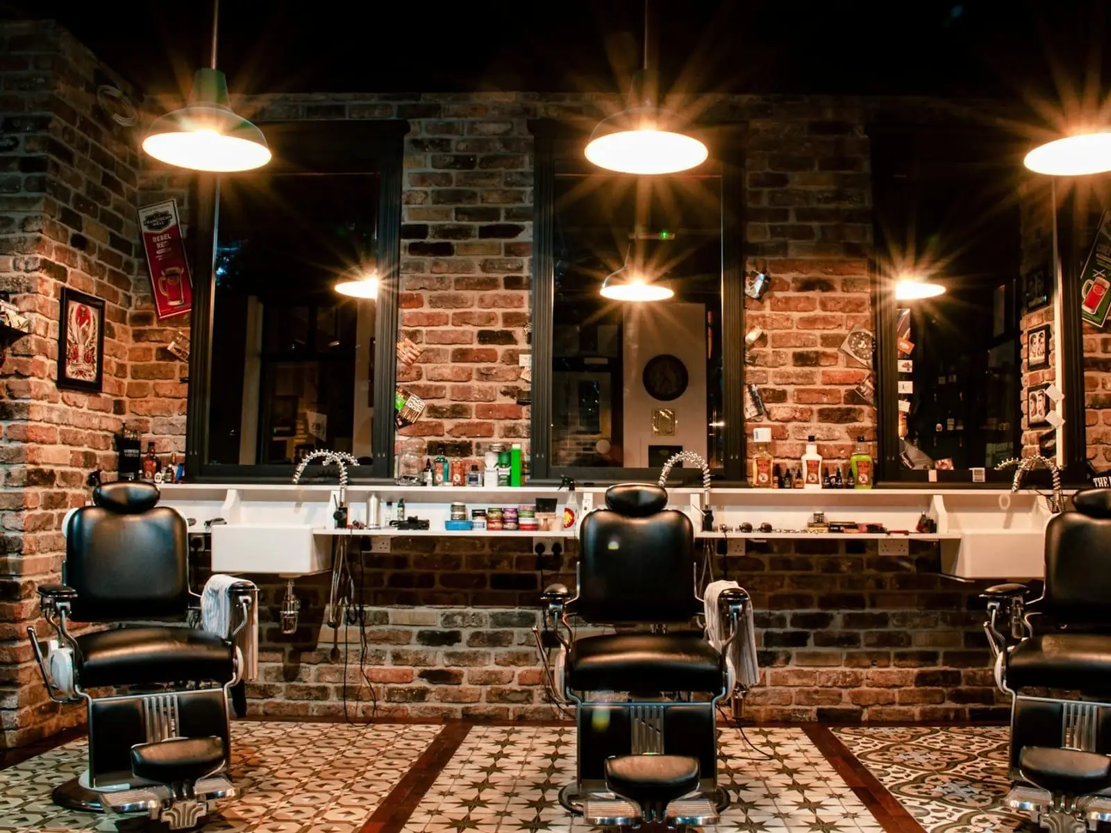 Interior de la barbería con sillones de piel y espejos iluminados